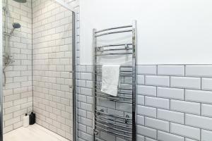 een badkamer met witte metrotegels en een douche bij Park House - Large 3 Bedroom Victorian House, 10 Mins from Manchester in Manchester +14 foto's