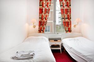 2 łóżka w małym pokoju z oknem w obiekcie Pensionat Svea w mieście Östersund