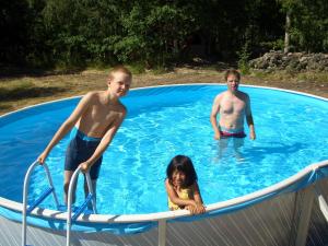 dos niños y una niña en una piscina en Kalliomajat, en Ylivalli