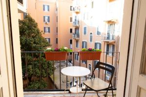 a balcony with two chairs and a table and flowers at Gregorios San Pietro Guesthouse in Rome