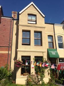 uma casa com bandeiras penduradas fora dela em Langland Road B&B em The Mumbles