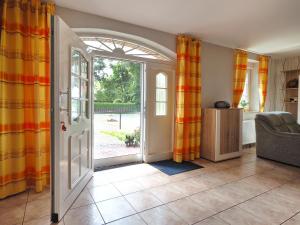 an open door to a living room with orange curtains at Ferienhof Scholbe in Schneverdingen
