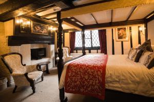 a bedroom with a bed and a fireplace and a desk at Mermaid Inn in Rye