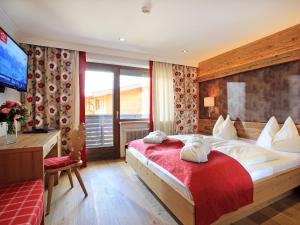 een hotelkamer met een bed en een televisie bij Hotel Alexander in Kirchberg in Tirol