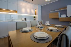 a dining room table with plates and wine glasses at Deluxe Apartments Opatija in Opatija