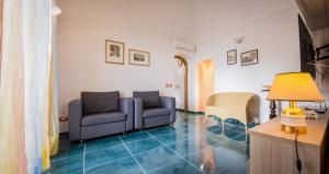 uma sala de estar com duas cadeiras e um sofá em Casa dei Greci em Amalfi