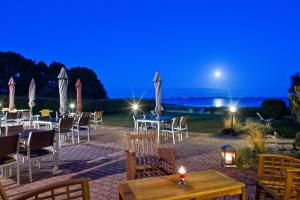 a restaurant with tables and chairs at night at Hôtel Restaurant Le Mur du Roy in Sarzeau