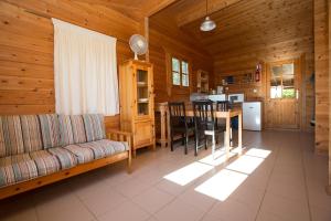 a living room with a couch and a table in a cabin at Les Chalets de Grazimis in Condom