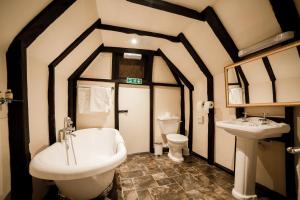 
a bathroom with a sink, toilet and bathtub at Mermaid Inn in Rye
