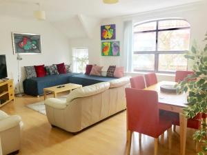 a living room with a couch and a table at 1 Fitzhamon Embankment APARTMENTS opposite Principality Stadium - LONG STAY OFFER in Cardiff