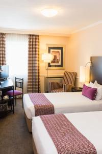 A bed or beds in a room at Mercure Johannesburg Randburg