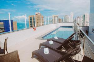 a balcony with chairs and a swimming pool on a building at Aquidabã Praia Hotel in Fortaleza