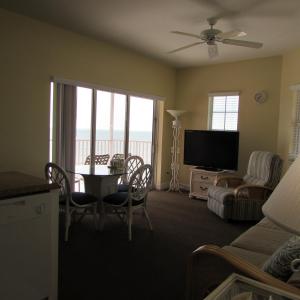 uma sala de estar com uma televisão e uma mesa e cadeiras em Edison Beach House em Fort Myers Beach