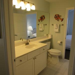 a bathroom with a sink and a toilet and a mirror at Edison Beach House in Fort Myers Beach
