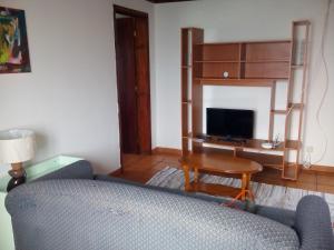 ein Wohnzimmer mit einem Sofa und einem Schreibtisch in der Unterkunft TINA - 3C - Alojamento Local -RRAL 1048 in Álamos Bravos