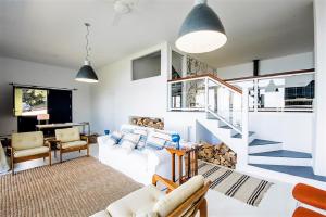 a living room with a white couch and a staircase at ATeRIAN LAZKANO ENEA in Getaria