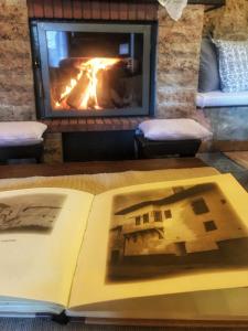 an open book on a table with a fireplace at Varosi Guesthouse in Edessa