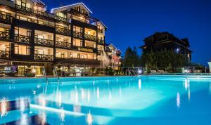 a hotel with a large swimming pool at night at Premier Luxury Mountain Resort in Bansko