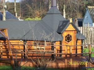 a small wooden house with a roof on a fence at The Hobbit House in Fort William