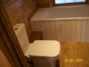 a small bathroom with a toilet and a bath tub at The Hobbit House in Fort William