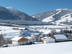un pueblo cubierto de nieve con montañas en el fondo en Residence Iris, en Valdaora
