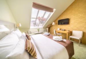 Schlafzimmer mit einem großen weißen Bett und einem Schreibtisch in der Unterkunft Grandium Hotel Prague in Prag