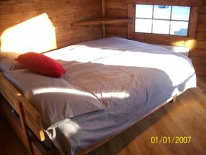 a bedroom with a bed with a red pillow on it at The Hobbit House in Fort William