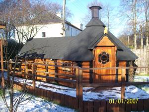 a log cabin with a black roof in the snow at The Hobbit House in Fort William