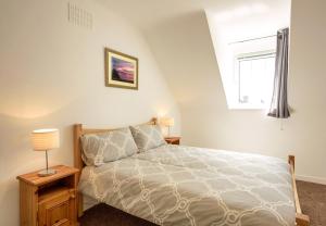1 dormitorio con cama y ventana en Ballybunion Cottages No 22 en Ballybunion