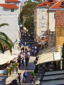 un grupo de personas caminando por una calle con edificios en Apartments Goda Center Of Split, en Split