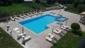 uma vista sobre uma piscina com espreguiçadeiras em Jenny Hotel em Laganas