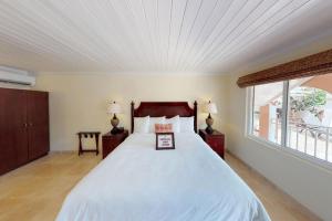 1 dormitorio con 1 cama blanca grande y ventana en Company House Hotel, en Christiansted