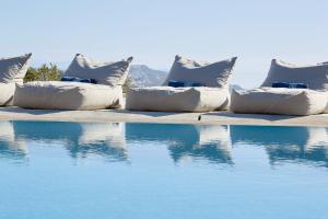 una fila de almohadas sentadas junto a una piscina en Amare Mykonos en Tourlos