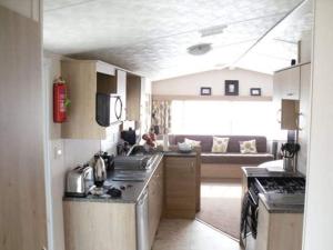 a kitchen with a sink and a couch in a room at 8 Berth Northshore (Warmth) in Winthorpe