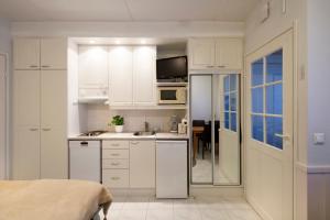 cocina blanca con fregadero y microondas en Polar Star Moonlight Apartments, en Levi