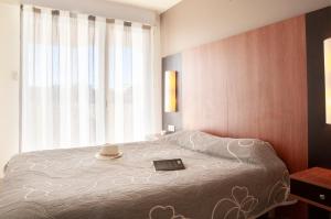 een slaapkamer met een bed met een hoed erop bij Résidence Les Flamants Roses in Canet-en-Roussillon