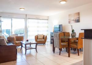 a living room with a table and chairs at Résidence Les Flamants Roses in Canet-en-Roussillon