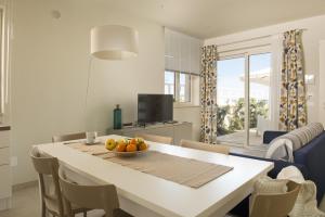 a kitchen with a table with a bowl of fruit on it at Vilu Suite Mare in Polignano a Mare