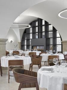 a restaurant with white tables and chairs and a white ceiling at Lotrinský hotel in Velké Pavlovice