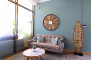 a living room with a couch and a surfboard on the wall at Vila Castelo Parque in Ferragudo