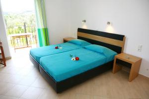 a bedroom with a bed with two flowers on it at Villa Thomas Valtos beach in Parga