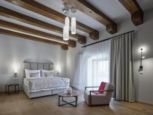 a bedroom with a bed and a chair and a table at Lotrinský hotel in Velké Pavlovice