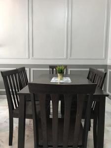 a black table with two chairs and a plant on it at LEPAK-LEPAK HOMESTAY @ INDERA MAHKOTA in Kuantan