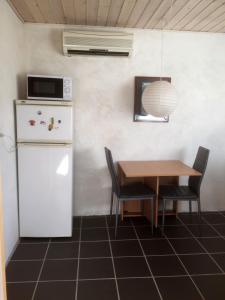 a kitchen with a table and a refrigerator and a microwave at Understedvej 103 in Sæby