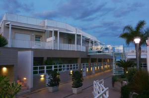 a building with a balcony and a palm tree at Vilu Suite Mare in Polignano a Mare