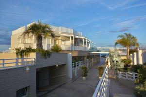 a building with palm trees and the beach at Vilu Suite Mare in Polignano a Mare