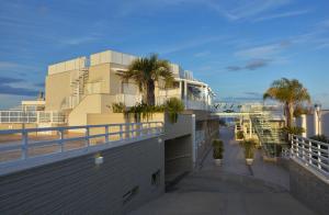 a building with palm trees on the side of it at Vilu Suite Mare in Polignano a Mare