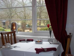 a table with a white table cloth and a window at Glenwood Guesthouse Betws-y-coed in Betws-y-coed
