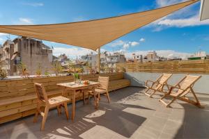 a patio with a table and chairs on a roof at Maryflower Premium Apartments Piraeus in Piraeus