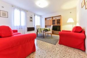 uma sala de estar com duas cadeiras vermelhas e uma mesa em Mimosa Apartment em Veneza